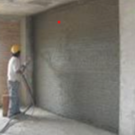 Trabajador aplicando material aislante en pared