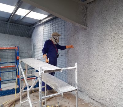Trabajador comprobando la correcta aplicación de material aislante en pared