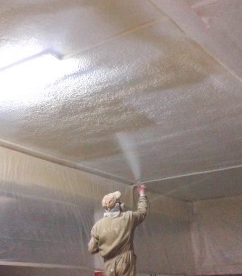 Trabajador aplicando producto aislante en el techo de una habitación