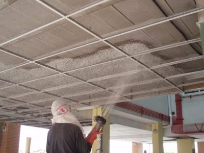 Trabajador aplicando lana de roca en techo como aislante